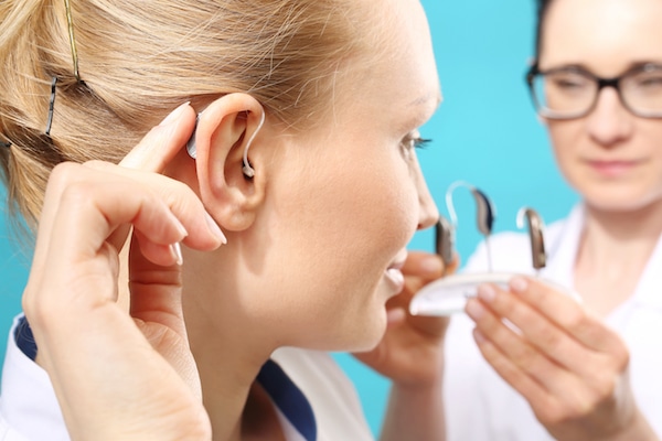 Young woman assumes a hearing aid