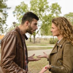 man and woman standing in a park talking