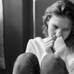 sad girl leaning against a wall