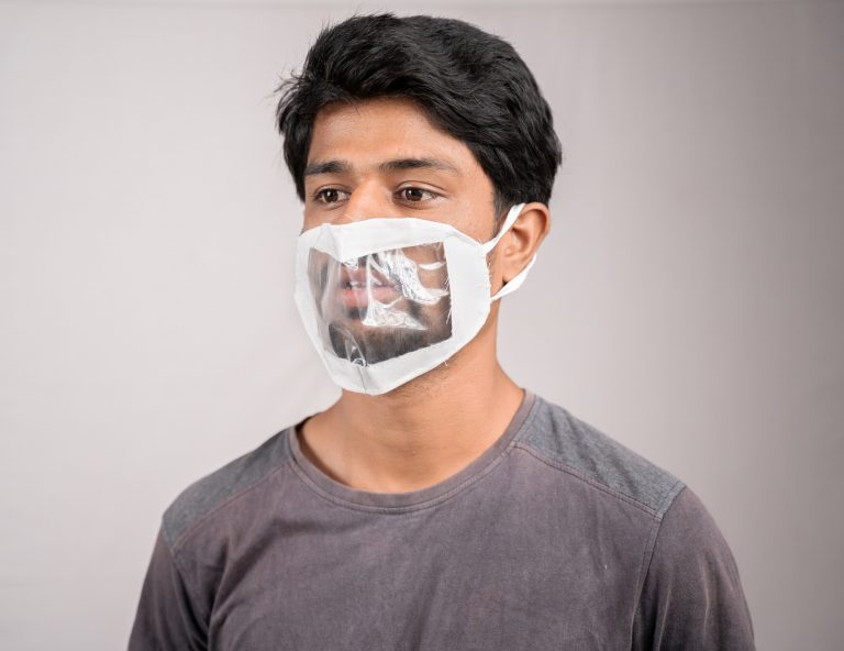 Strategies for Talking Through Your Face Mask young man with transparent Medical face mask, to help hearing impermeant or deaf people to understand lipreading during coronavirus or covid-19 outbreak.