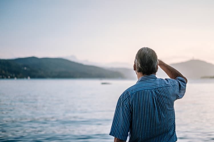 man-lake-hearing-loss-memory Man stares out at a lake.