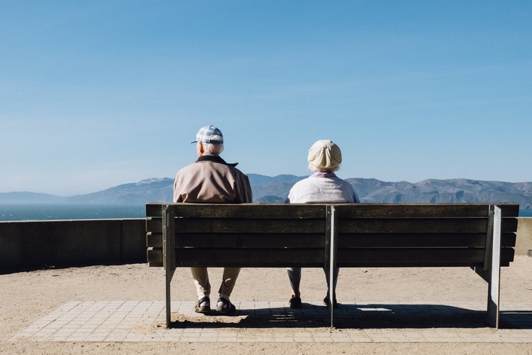 couple-hearing-loss-cognitive-decline Couple sitting together on a bench.