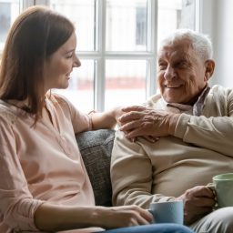 Young adult woman talking to her father about hearing loss.