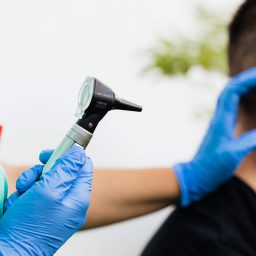 Doctor examining a man's ear.