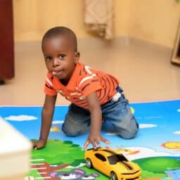 Little boy playing on a mat at daycare.