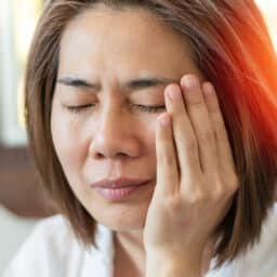 close-up image of a woman putting her head in her hands