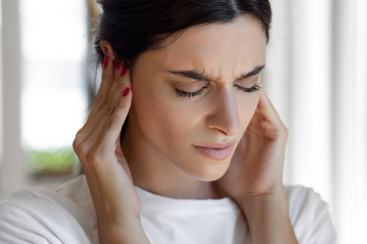 Woman with hyperacusis holding her ears.