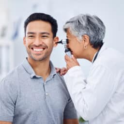 Doctor looking in her patient's ear