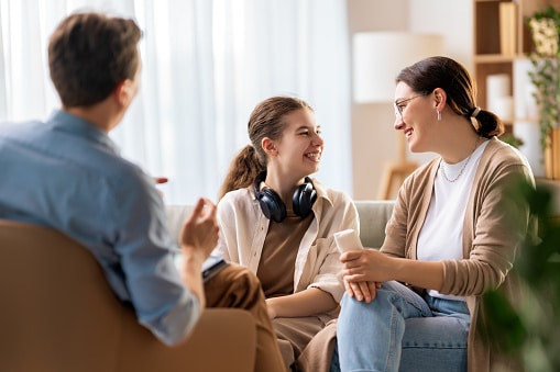 Happy family of three chatting in the living room.
